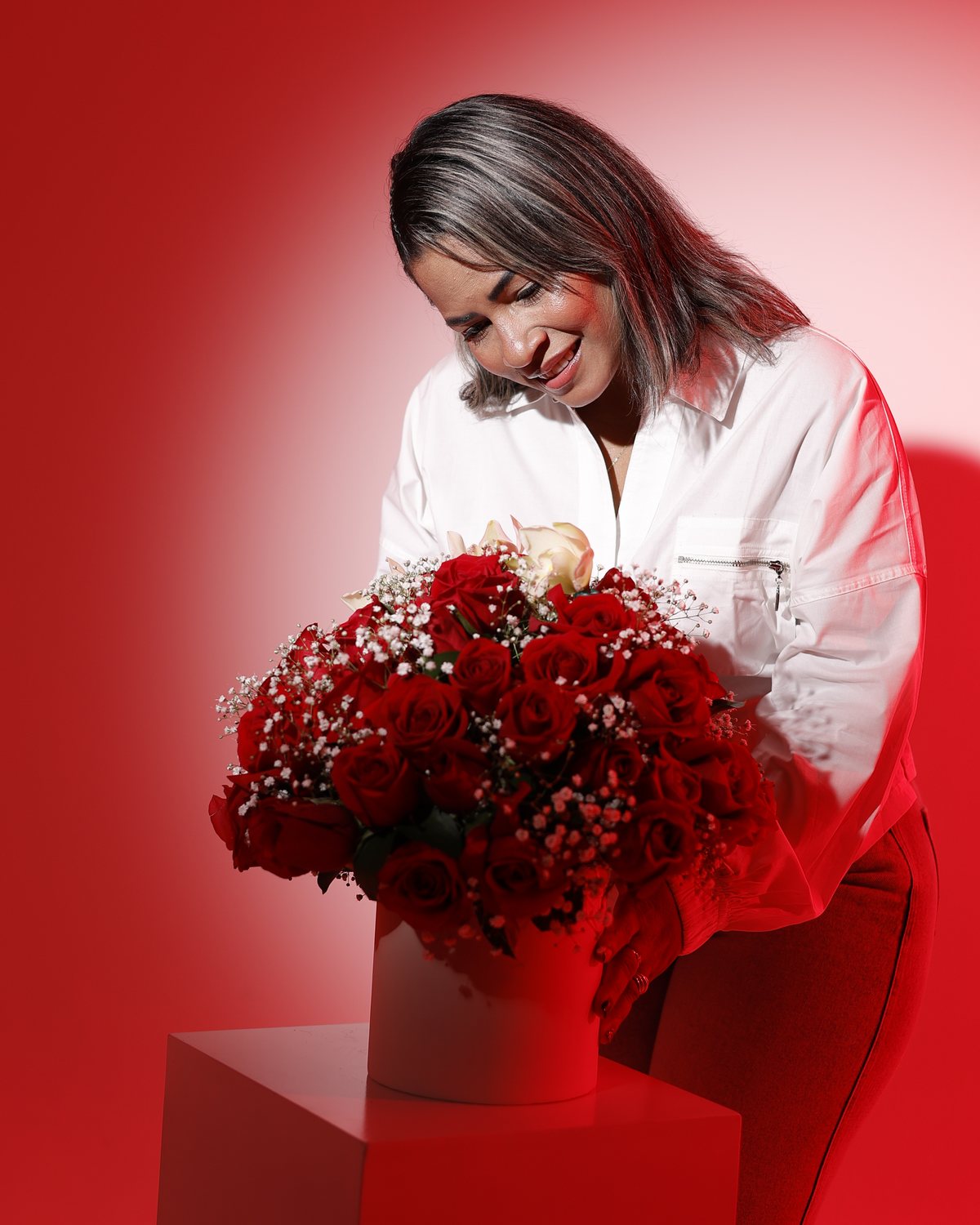 Irma Calderón arreglando un bouquet de rosas rojas en su taller